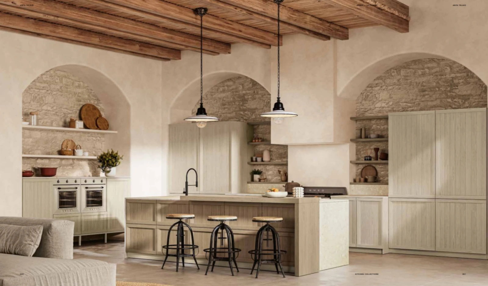 Cucina chiara con isola in un ambiente con archi e travi