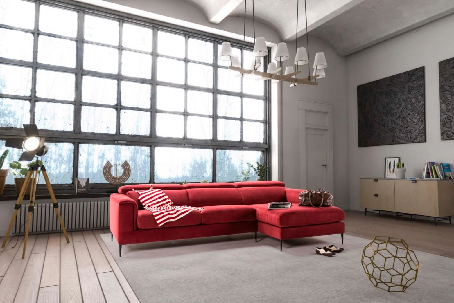 Divano rosso con chaise longue in un ambiente con grandi finestre