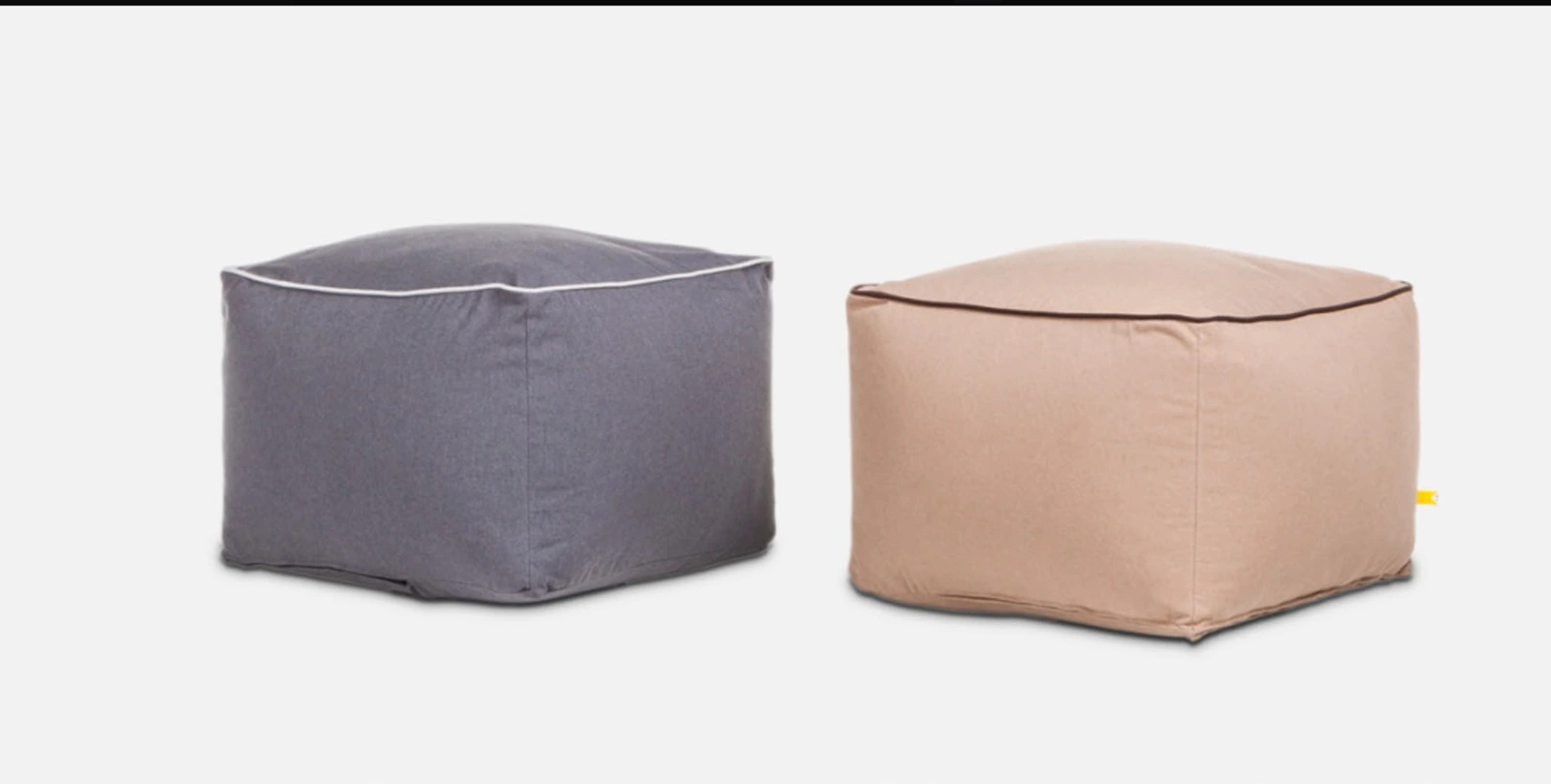 Due pouf bassi, grigio e rosa, su fondo chiaro